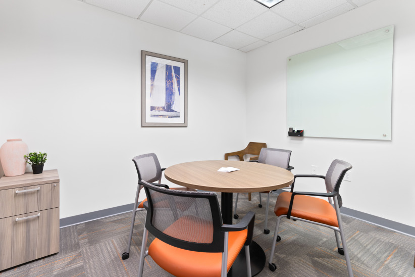 Modern office meeting room with round table and chairs for collaboration and productivity.