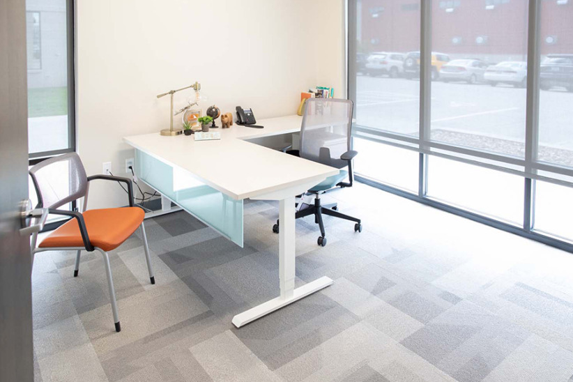 Modern office workspace with glass windows and ergonomic furniture.