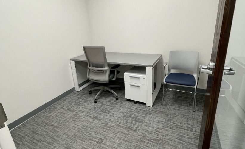 Small office space with desk, chair, and visitor seating, ideal for coworking or private work areas at Office Evolution.