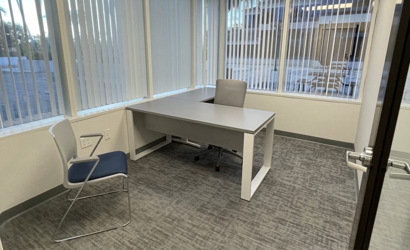 Modern office workspace with desk and chairs at Office Evolution. Ideal for professional meetings and remote work solutions.