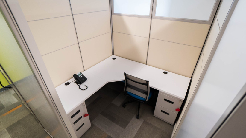 Private office cubicle with a desk and chair for remote work or meetings at Office Evolution.