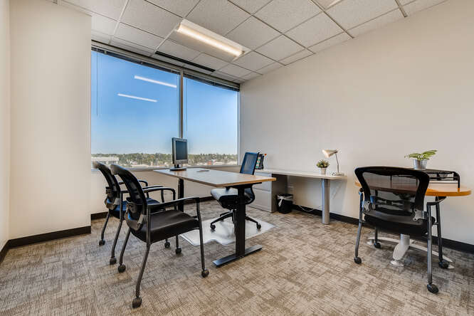 Modern office workspace with desks and chairs in a professional office environment.