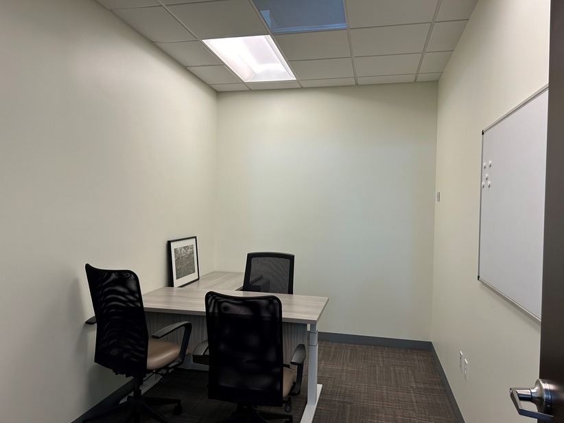 Office meeting room with white walls and modern furniture in a professional work environment.