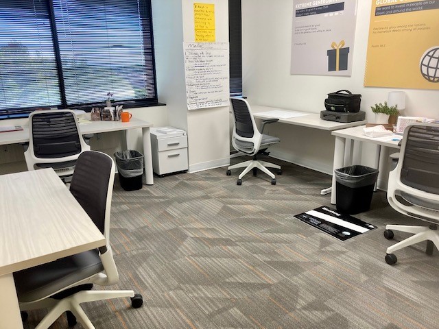 Modern coworking office space with desks, chairs, and meeting areas for flexible work environments, ideal for businesses.