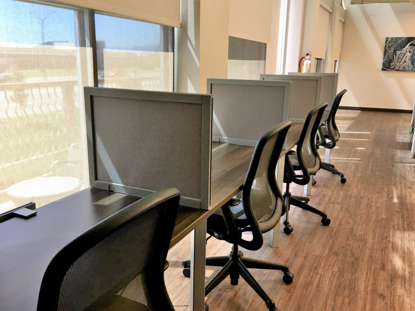 Modern coworking space with individual desks and ergonomic chairs at Office Evolution.