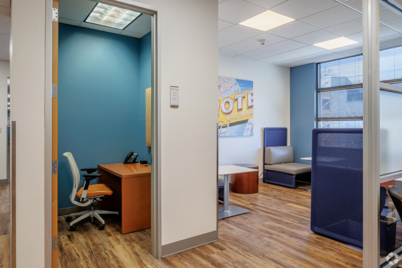 Modern office reception and waiting area at Office Evolution with comfortable seating and natural lighting.