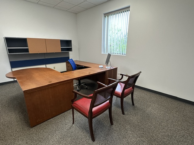 Office workspace with desk, chairs, and storage shelves for professional remote work.