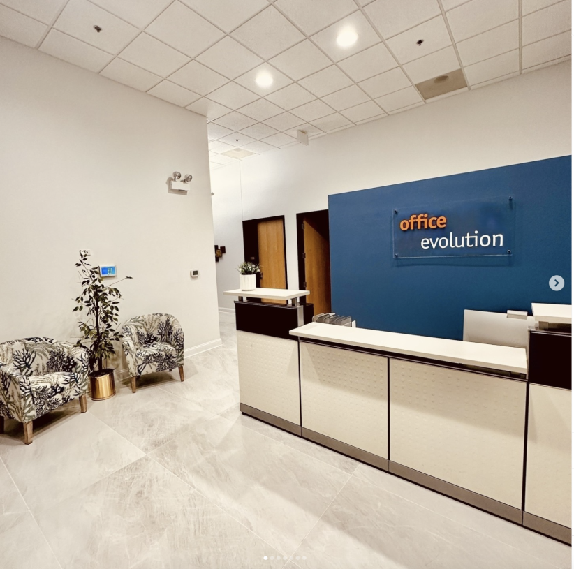 Office evolution reception area with modern decor and seating options, showcasing a professional coworking space.