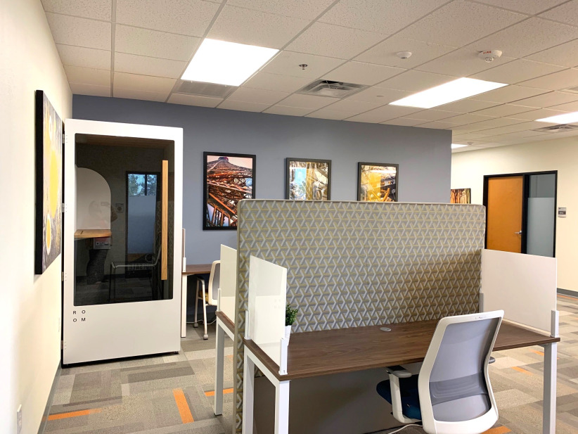 Co-working office space with private phone booths and modern seating.