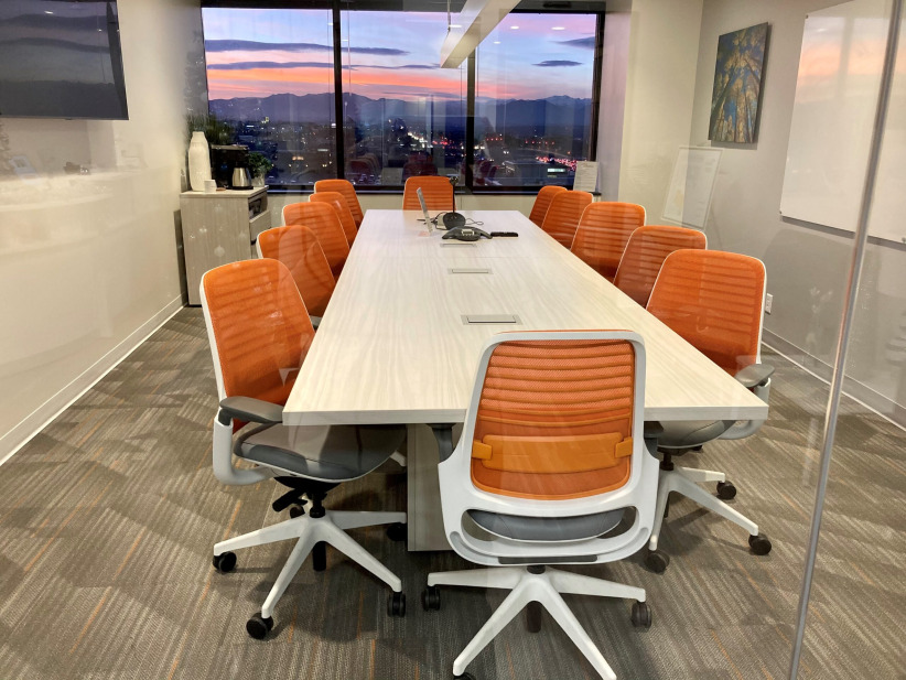 Modern office conference room with large table and comfortable chairs in a professional workspace.