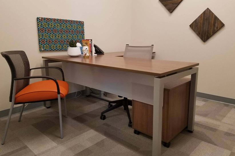 Office evolution coworking space with modern desk and chairs in a professional office setting.