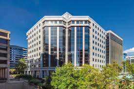 Modern multi-story office building with glass windows and urban surroundings.