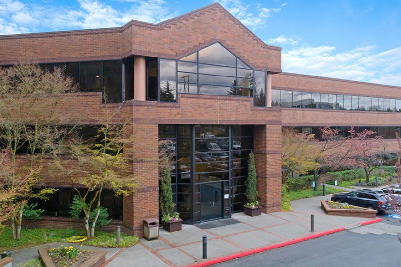 Modern office building with glass windows and brick facade, perfect for workspace solutions.