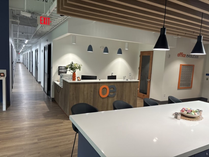 Flexible office reception area with modern decor and seating at Office Evolution coworking space.