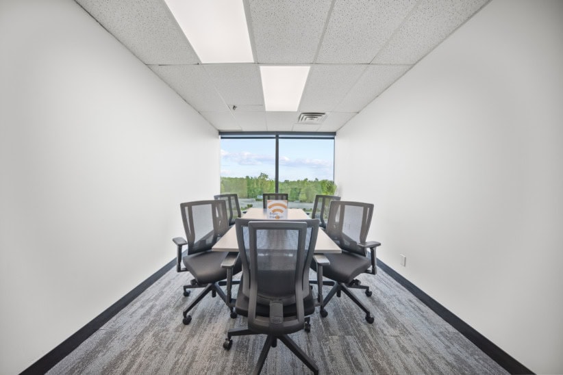 Modern office conference room with large window and ergonomic chairs for meetings and collaboration.