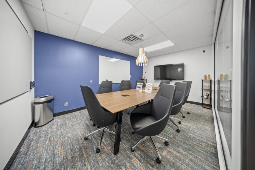 Flexible office meeting room with conference table and chairs at Office Evolution.