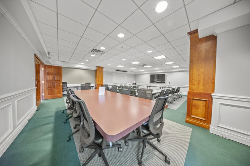 Modern conference room with large table and ergonomic chairs in office space.