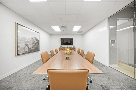 Modern conference room with a large wooden table and leather chairs in Las Colinas.