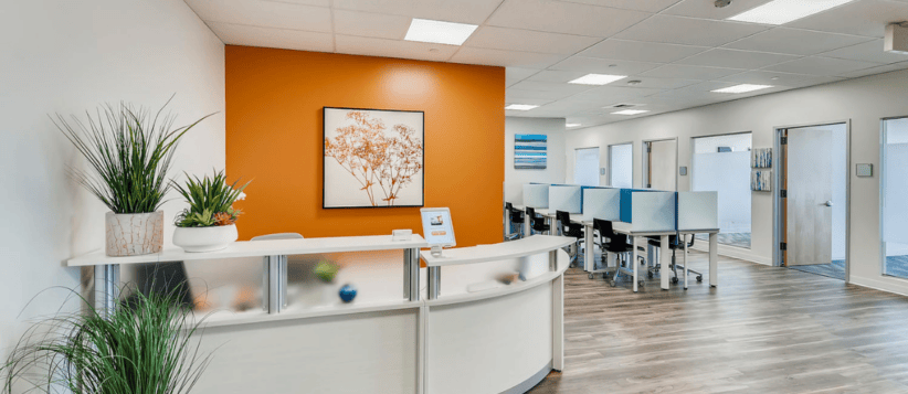 Modern coworking space with desks, plants, and vibrant decor for small business growth.