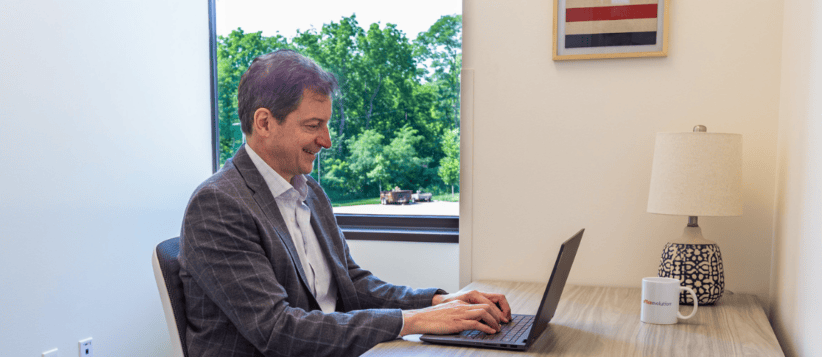 Businessman working on a laptop in a modern coworking space.