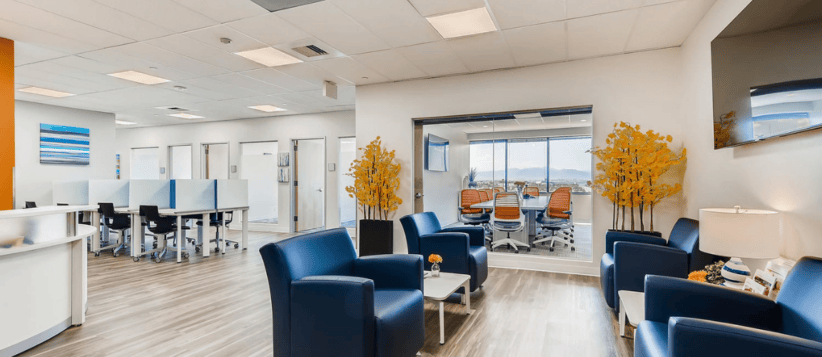 Modern coworking space with comfortable seating and large windows.
