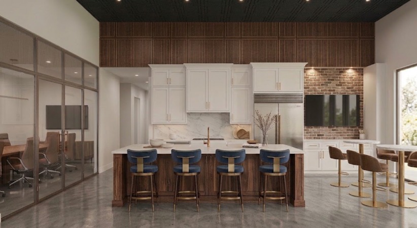 Modern shared kitchen with white cabinetry, marble backsplash, stainless refrigerator, walnut island with four navy bar stools, brick accent wall with TV, and adjacent café tables.