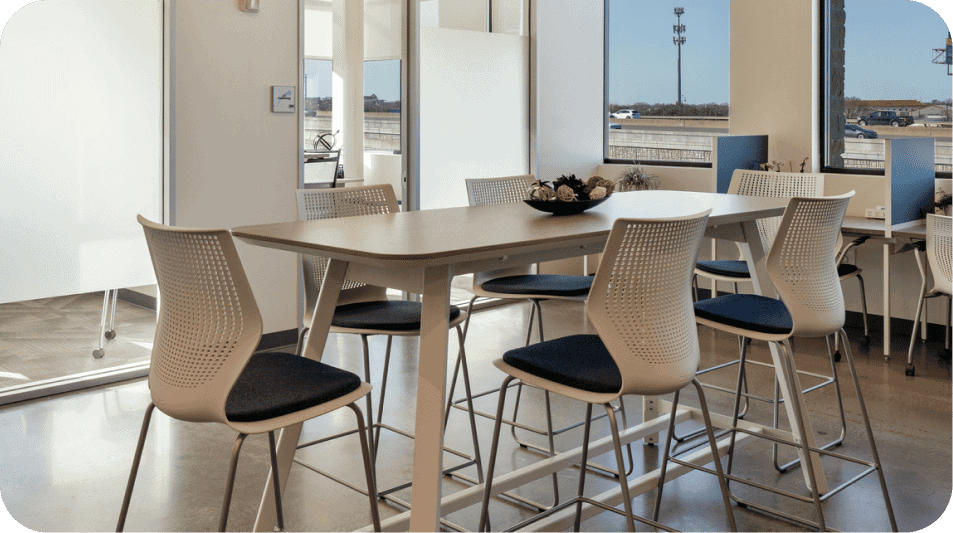 Modern office meeting room with a large table and chairs near windows.