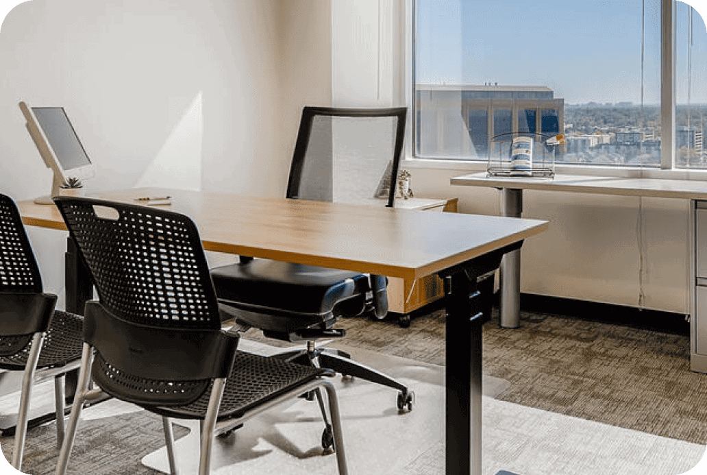 Modern office with a large window and a conference table with chairs.